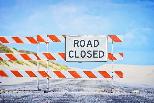 Road Closed Sign Against Blue Sky